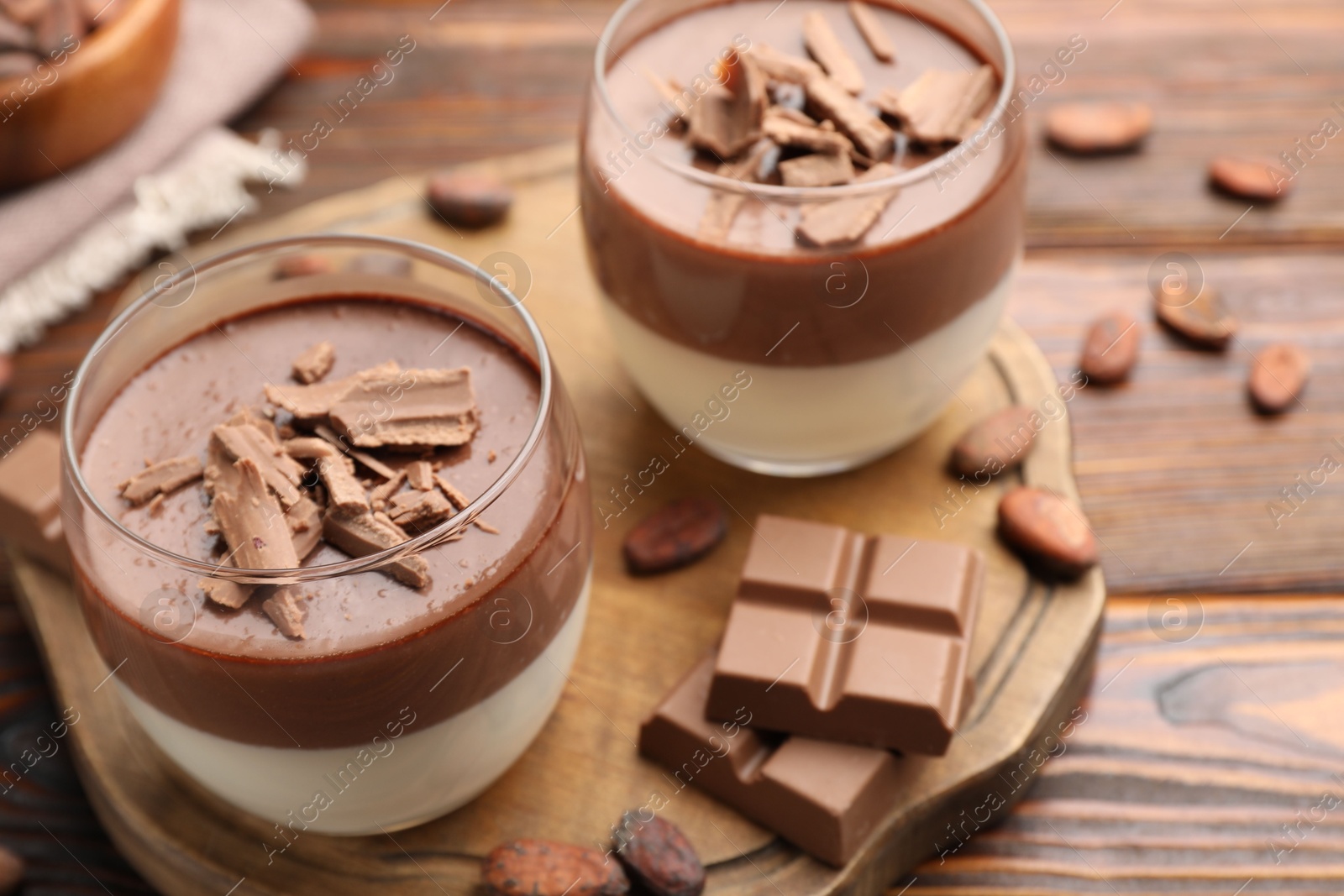 Delicious panna cotta with chocolate and cocoa beans on wooden table, closeup Photo of Delicious panna cotta with chocolate and cocoa beans on wooden table, closeup