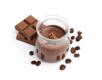 Photo of Delicious chocolate panna cotta in glass jar, coffee beans and chocolate pieces isolated on white