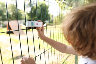 Photo of Little boy playing with toy car outdoors, closeup