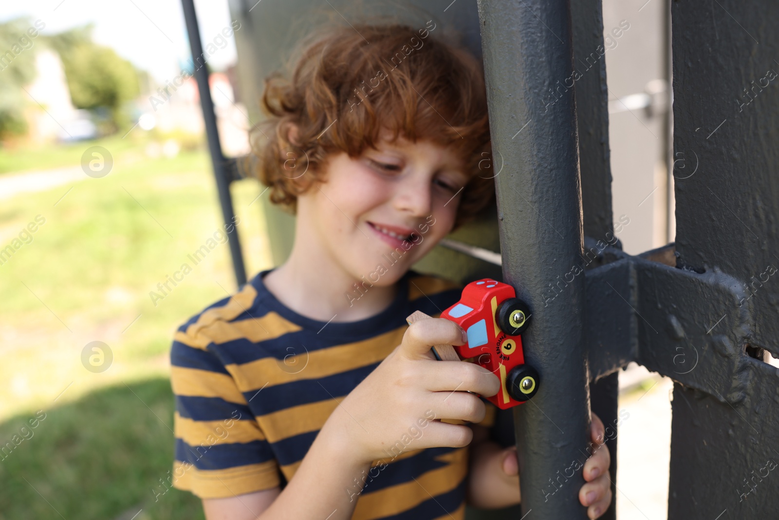 Little boy playing with toy car outdoors, selective focus Photo of Little boy playing with toy car outdoors, selective focus