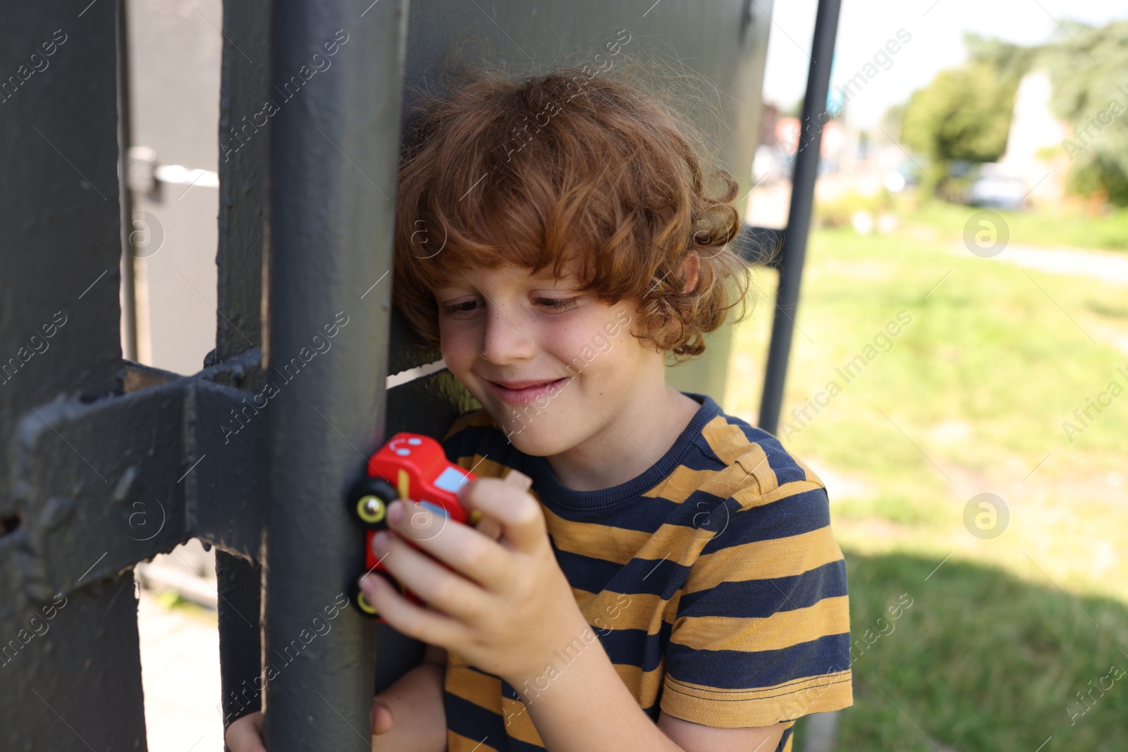 Little boy playing with toy car outdoors Photo of Little boy playing with toy car outdoors