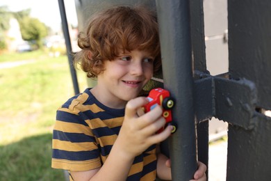 Photo of Little boy playing with toy car outdoors
