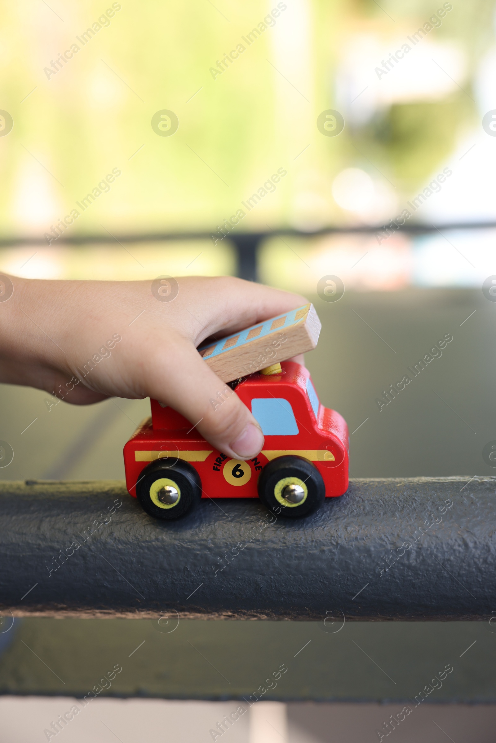 Photo of Little boy playing with toy car outdoors, closeup