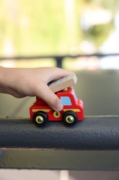 Photo of Little boy playing with toy car outdoors, closeup