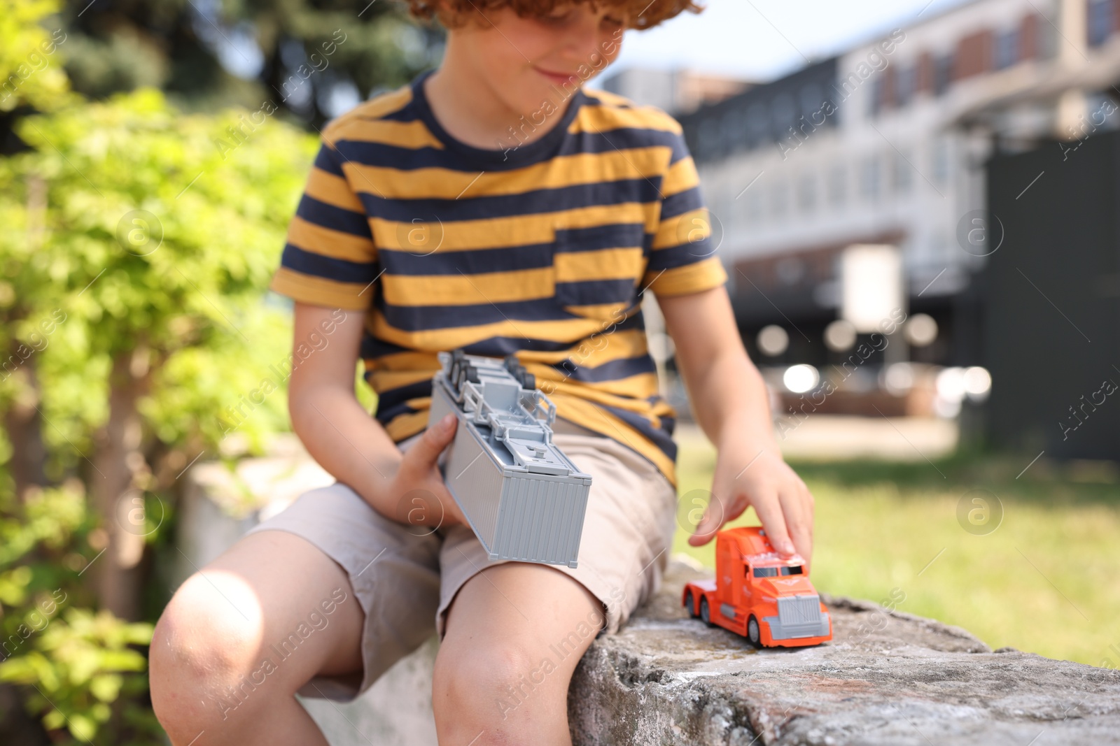 Little boy playing with toy car outdoors, selective focus Photo of Little boy playing with toy car outdoors, selective focus