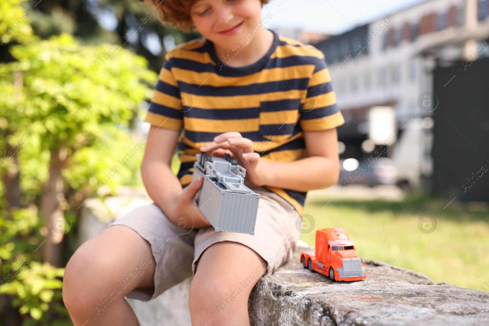 Little boy playing with toy car outdoors, selective focus Photo of Little boy playing with toy car outdoors, selective focus