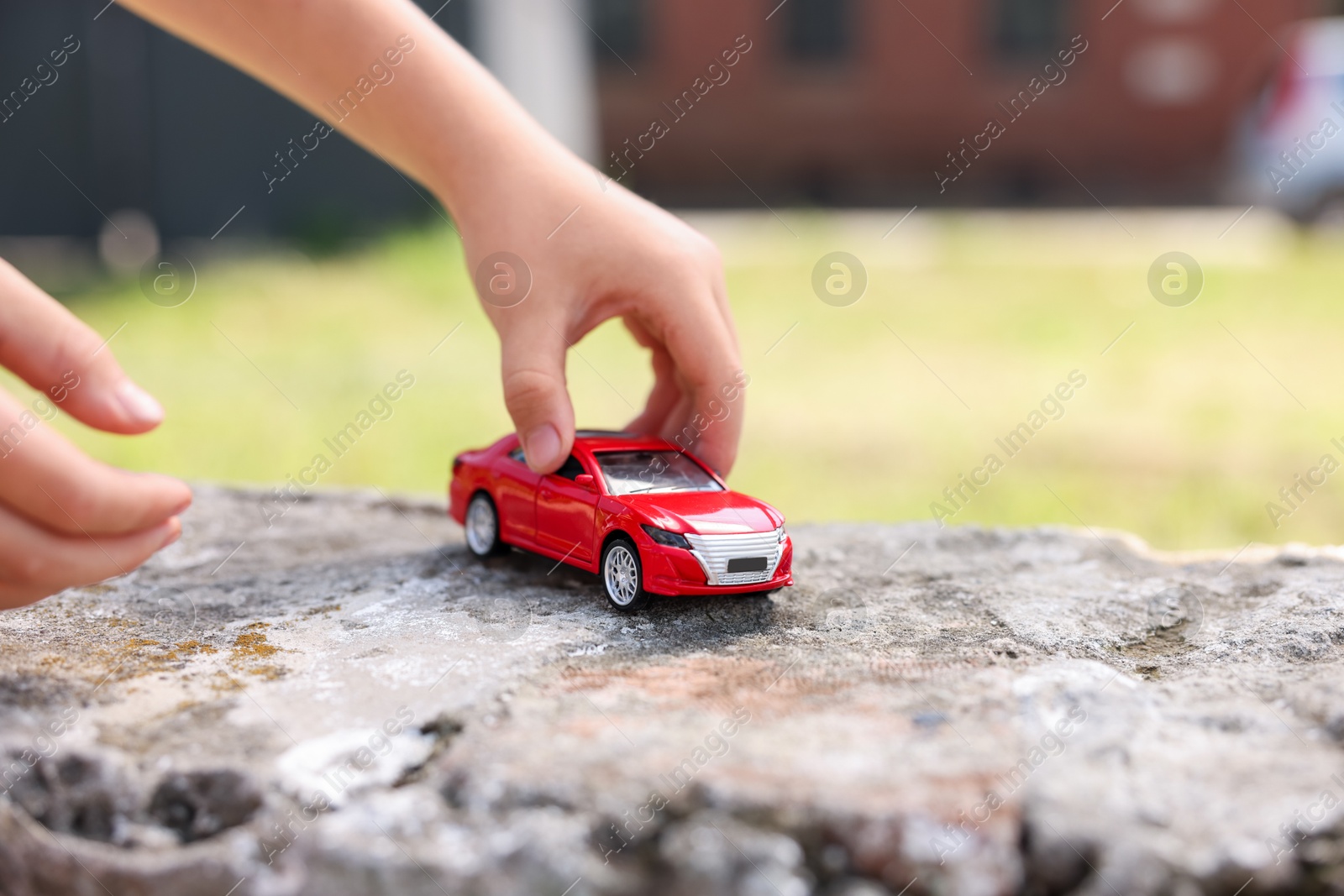 Little boy playing with toy car outdoors, closeup Photo of Little boy playing with toy car outdoors, closeup