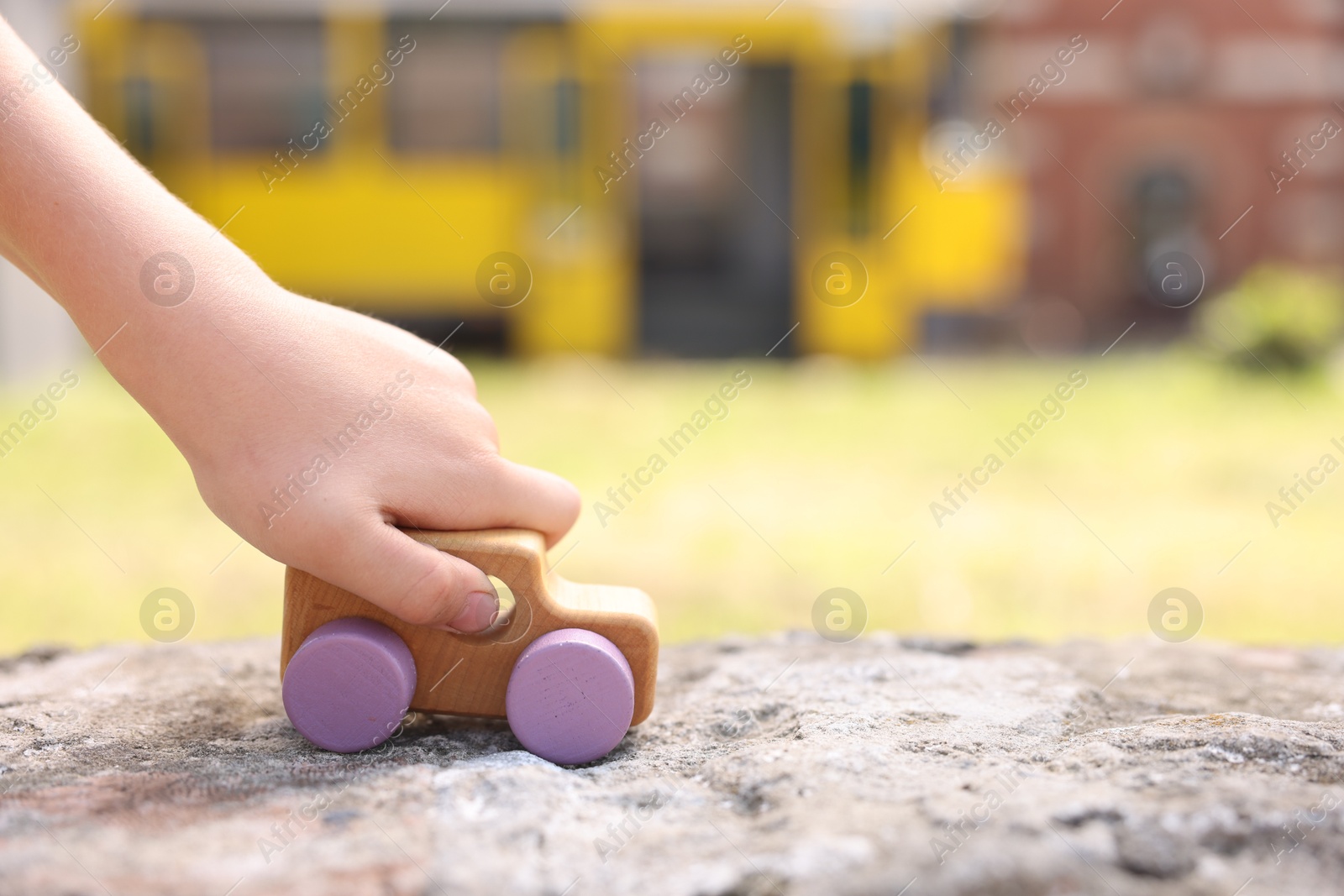 Little boy playing with toy car outdoors, closeup. Space for text Photo of Little boy playing with toy car outdoors, closeup. Space for text