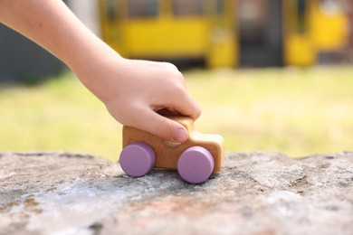 Photo of Little boy playing with toy car outdoors, closeup