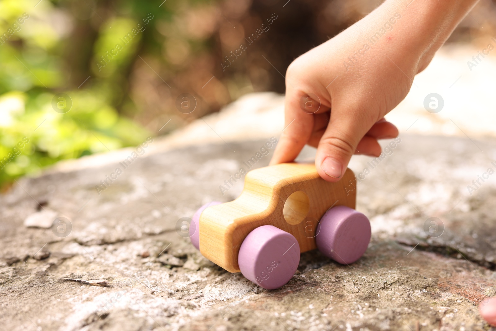 Little boy playing with toy car outdoors, closeup Photo of Little boy playing with toy car outdoors, closeup