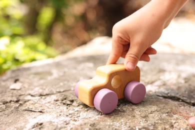 Photo of Little boy playing with toy car outdoors, closeup