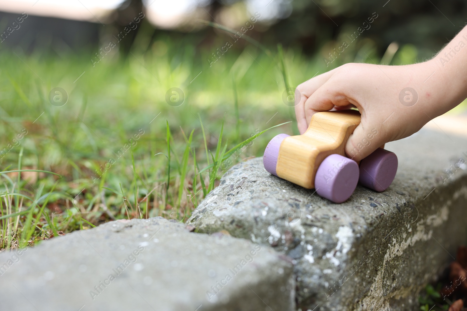 Little boy playing with toy car outdoors, closeup. Space for text Photo of Little boy playing with toy car outdoors, closeup. Space for text