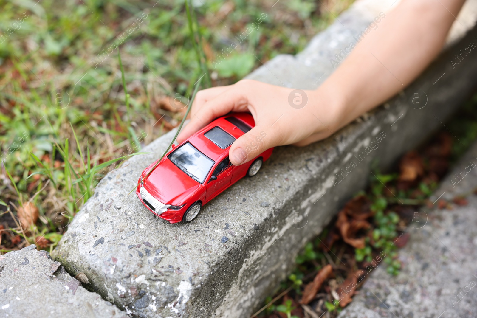 Little boy playing with toy car outdoors, closeup Photo of Little boy playing with toy car outdoors, closeup