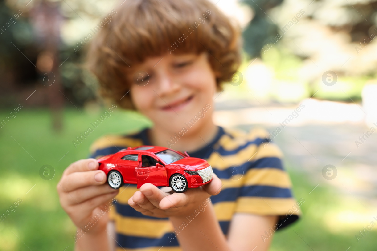 Little boy with toy car outdoors, selective focus Photo of Little boy with toy car outdoors, selective focus