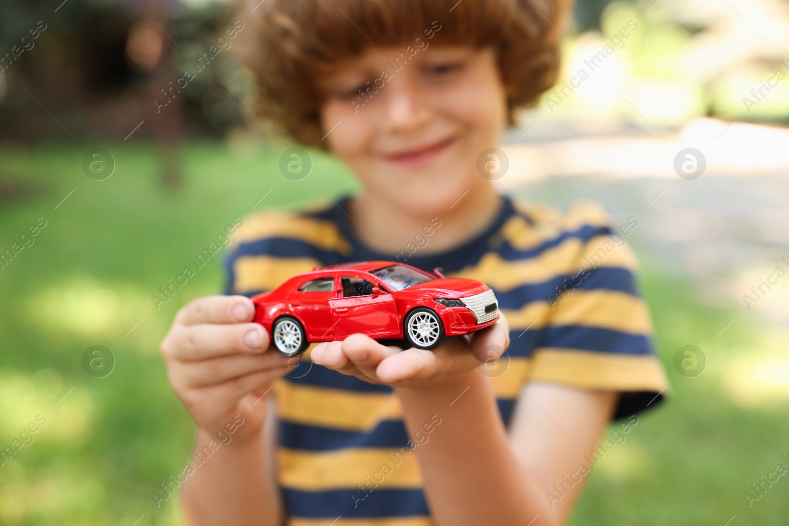 Little boy with toy car outdoors, selective focus Photo of Little boy with toy car outdoors, selective focus
