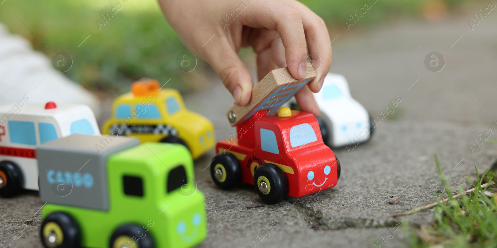 Little boy playing with toy cars outdoors, closeup Photo of Little boy playing with toy cars outdoors, closeup