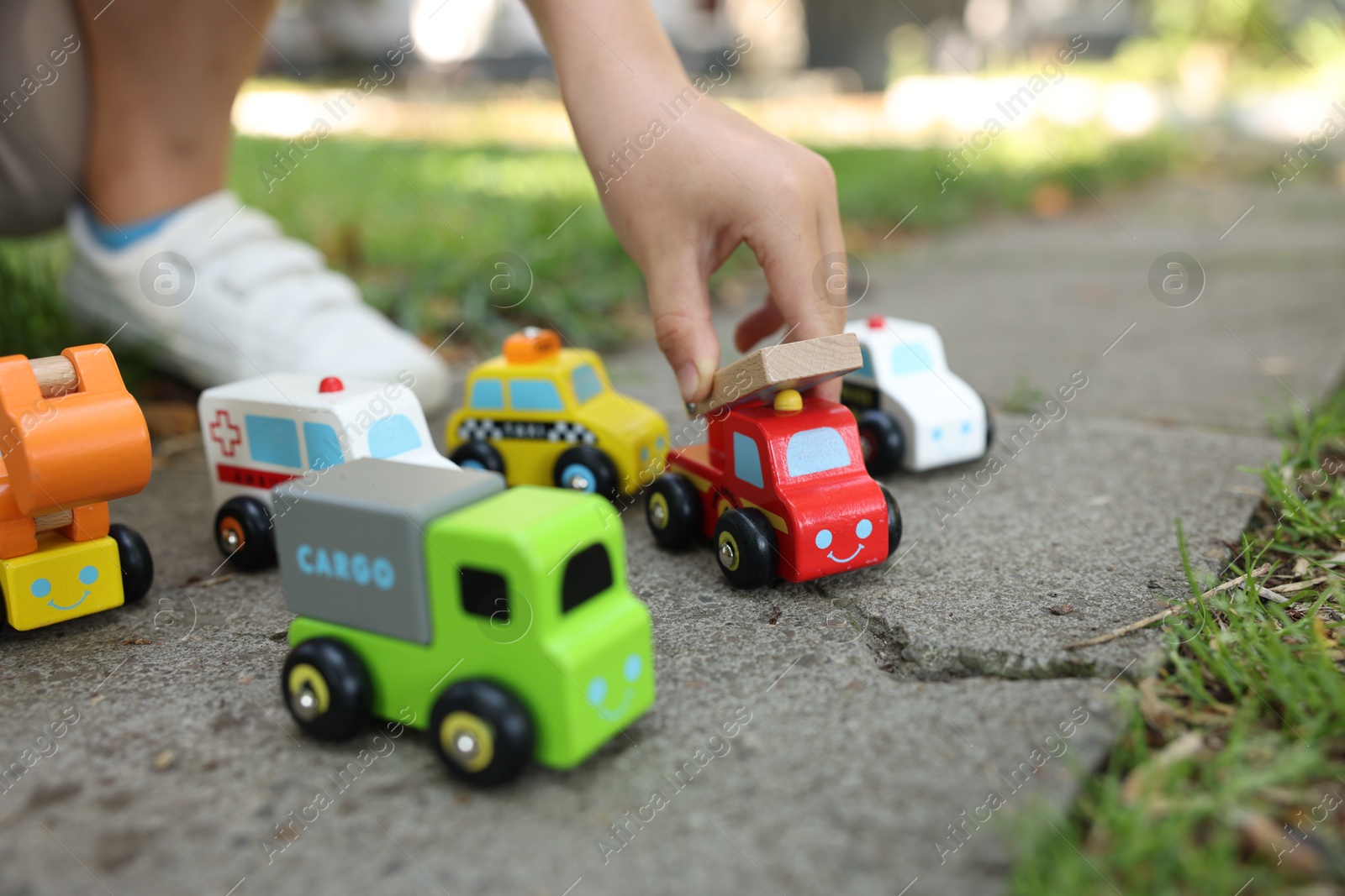 Little boy playing with toy cars outdoors, closeup Photo of Little boy playing with toy cars outdoors, closeup
