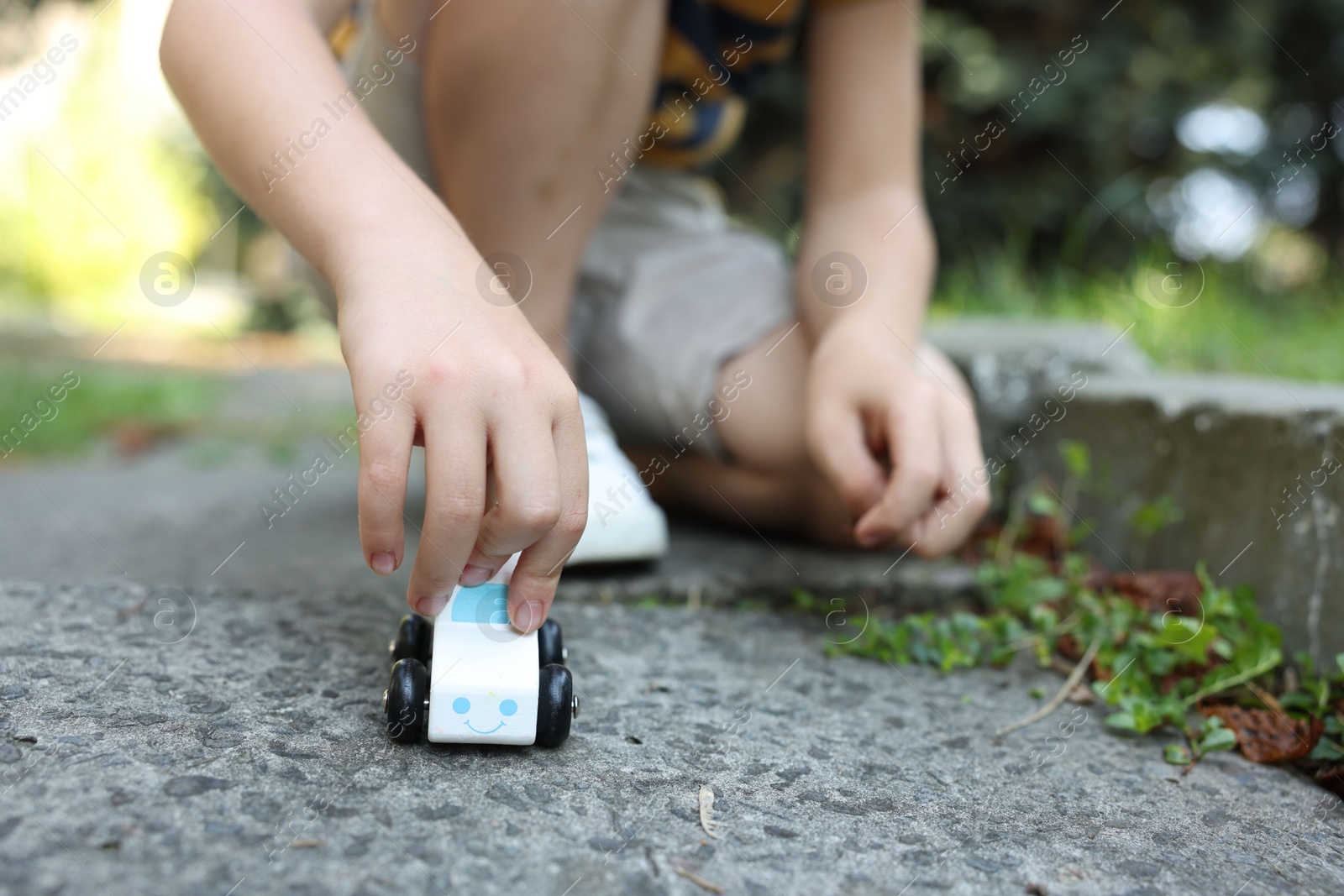 Little boy playing with toy car outdoors, closeup Photo of Little boy playing with toy car outdoors, closeup