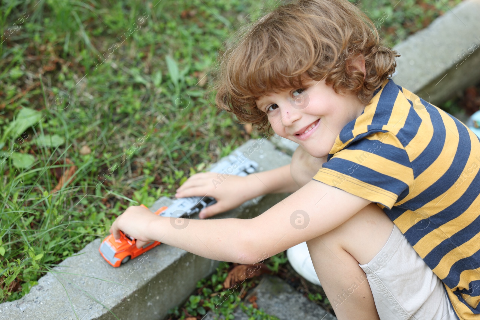 Little boy playing with toy car outdoors Photo of Little boy playing with toy car outdoors