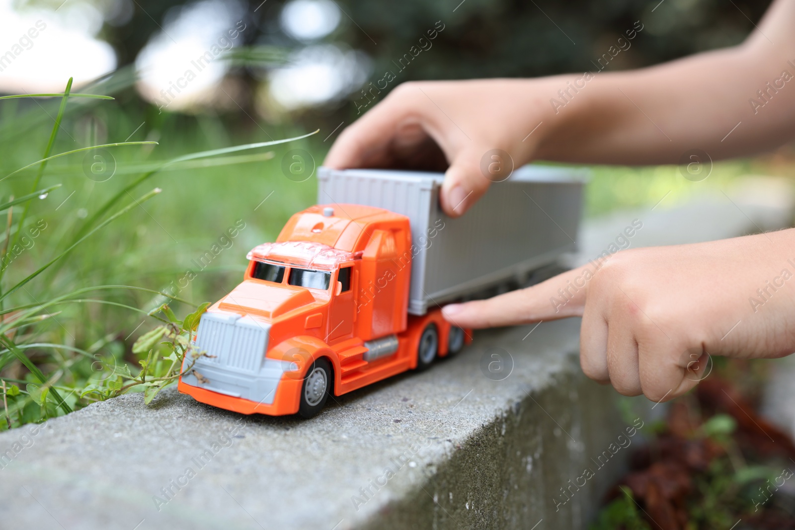 Little boy playing with toy car outdoors, closeup Photo of Little boy playing with toy car outdoors, closeup