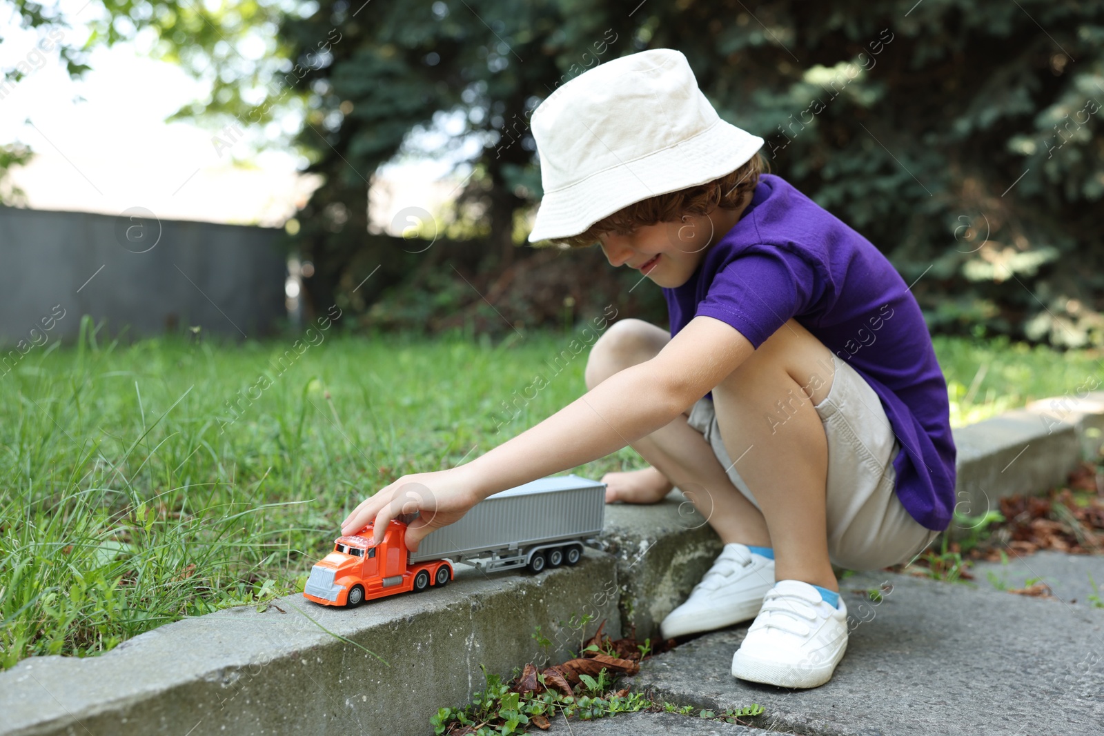 Little boy playing with toy car outdoors Photo of Little boy playing with toy car outdoors