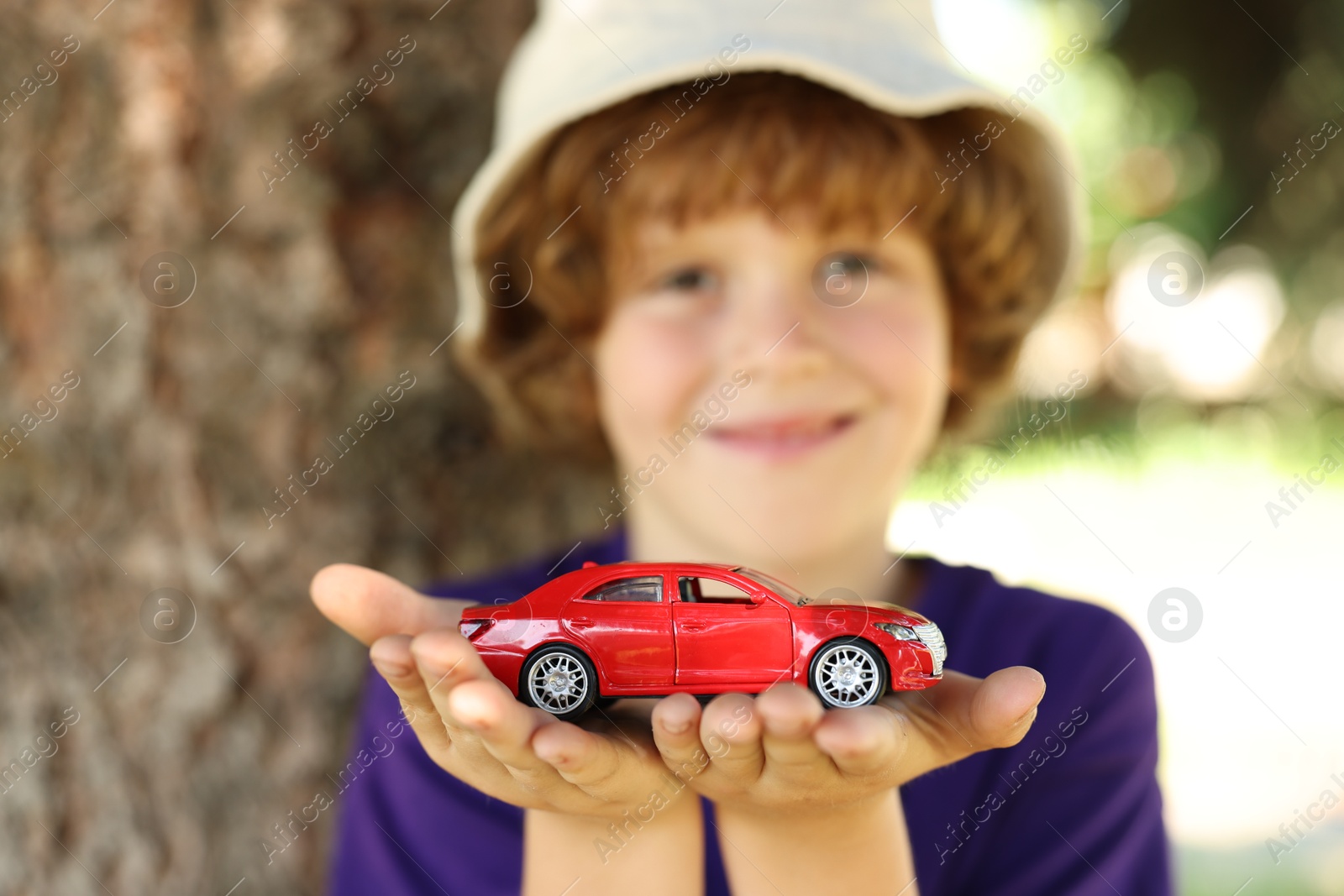 Little boy with toy car outdoors, selective focus Photo of Little boy with toy car outdoors, selective focus