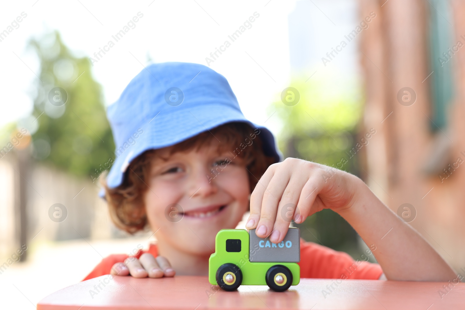 Little boy playing with toy car outdoors, selective focus Photo of Little boy playing with toy car outdoors, selective focus