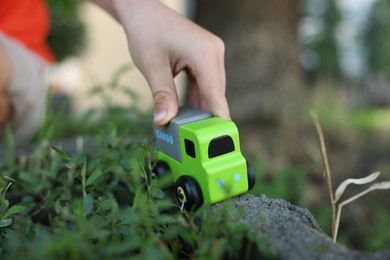 Photo of Little boy playing with toy car outdoors, closeup