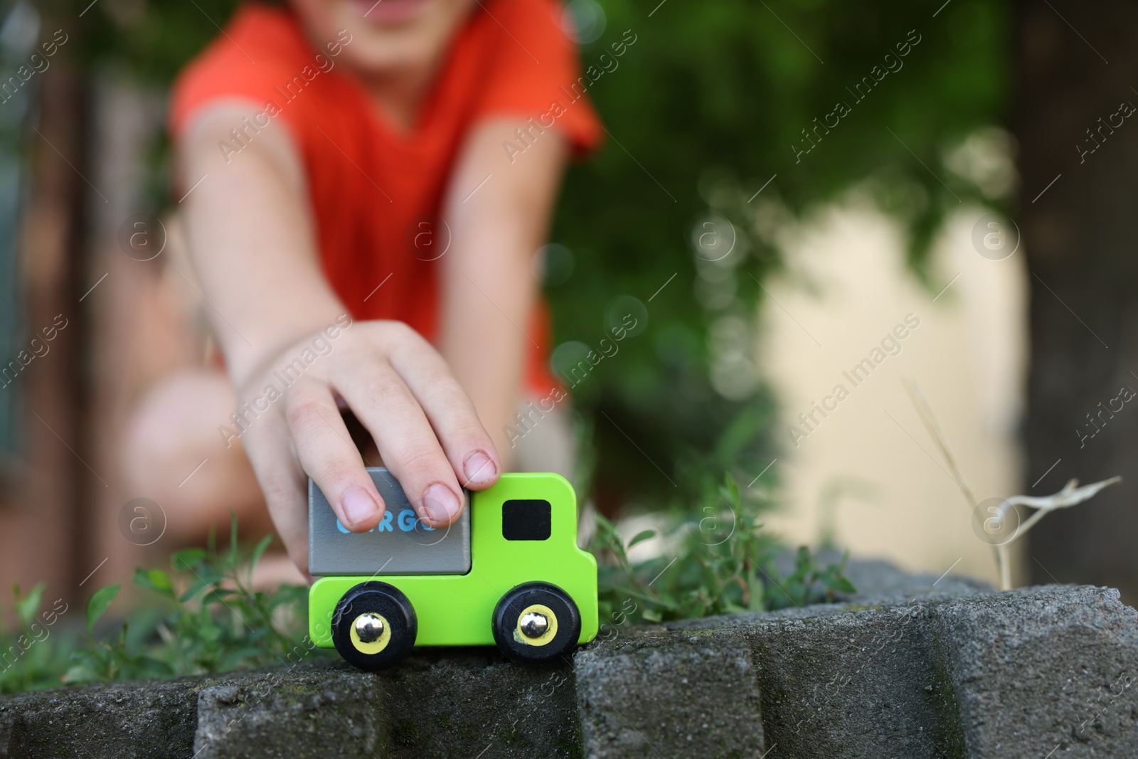 Little boy playing with toy car outdoors, closeup. Space for text Photo of Little boy playing with toy car outdoors, closeup. Space for text