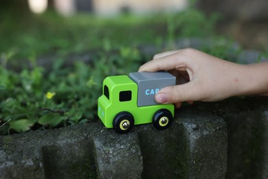 Photo of Little boy playing with toy car outdoors, closeup