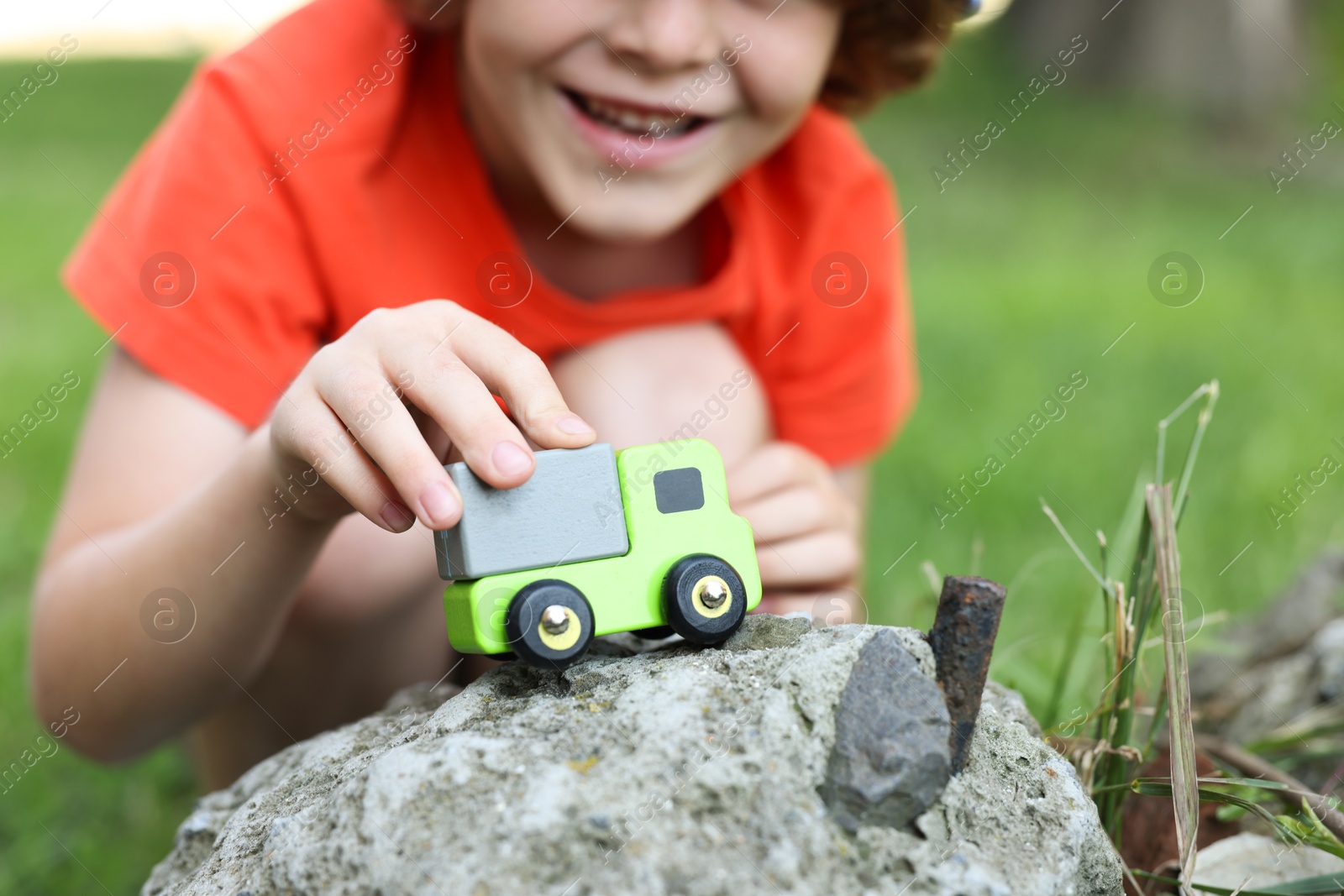 Little boy playing with toy car outdoors, closeup Photo of Little boy playing with toy car outdoors, closeup