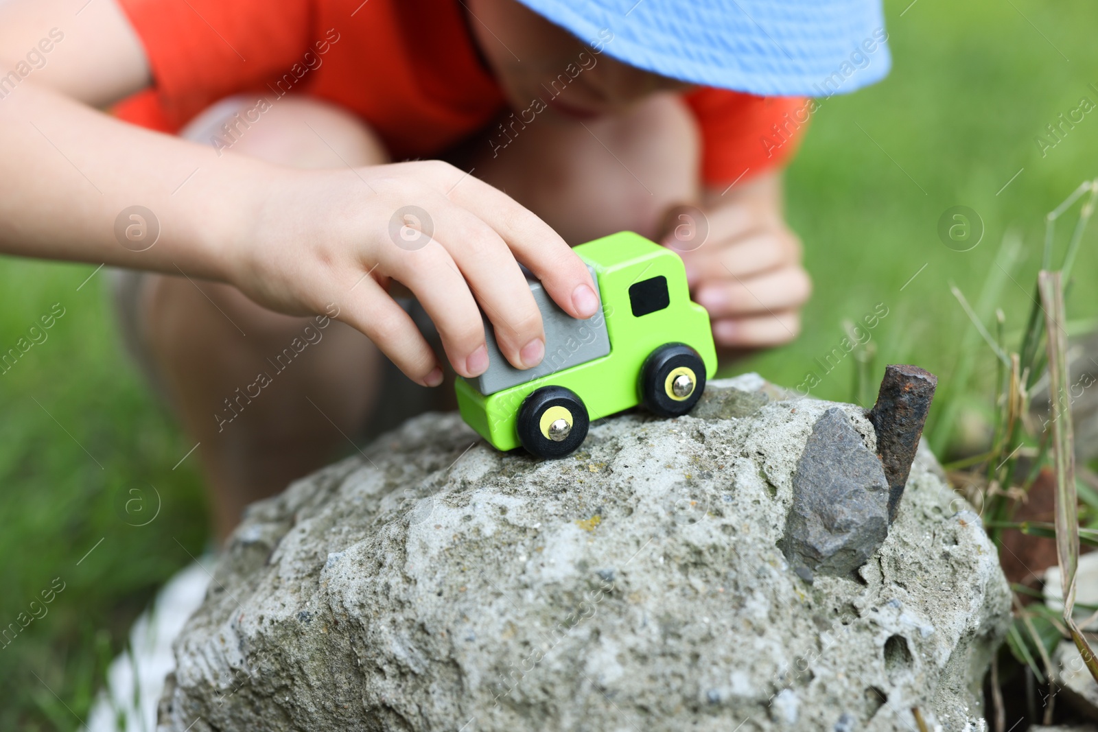 Little boy playing with toy car outdoors, closeup Photo of Little boy playing with toy car outdoors, closeup