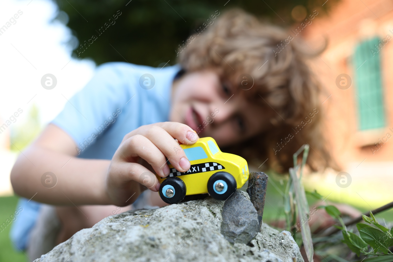 Little boy playing with toy car outdoors, selective focus Photo of Little boy playing with toy car outdoors, selective focus