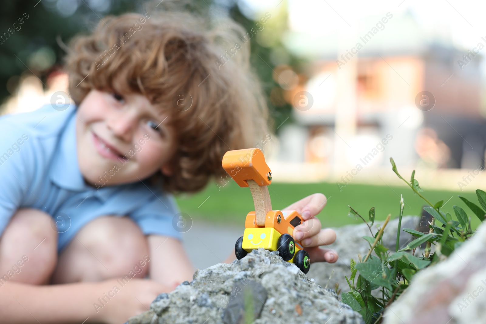 Little boy playing with toy car outdoors, selective focus Photo of Little boy playing with toy car outdoors, selective focus