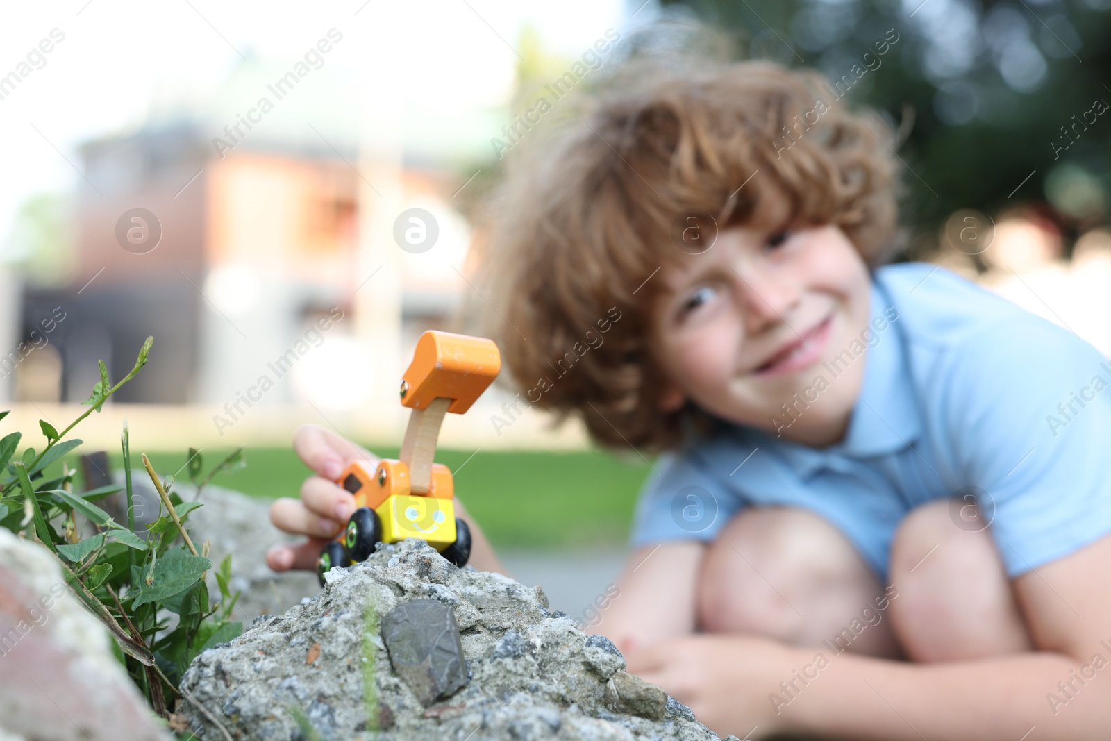 Little boy playing with toy car outdoors, selective focus Photo of Little boy playing with toy car outdoors, selective focus