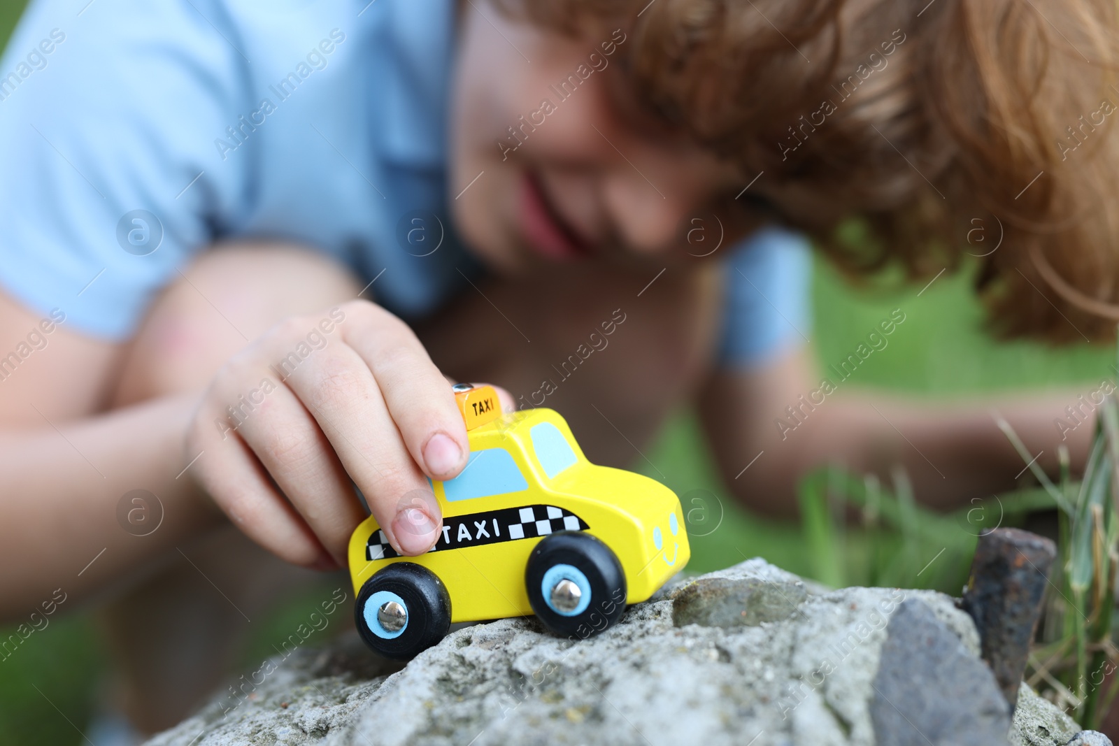 Little boy playing with toy car outdoors, selective focus Photo of Little boy playing with toy car outdoors, selective focus