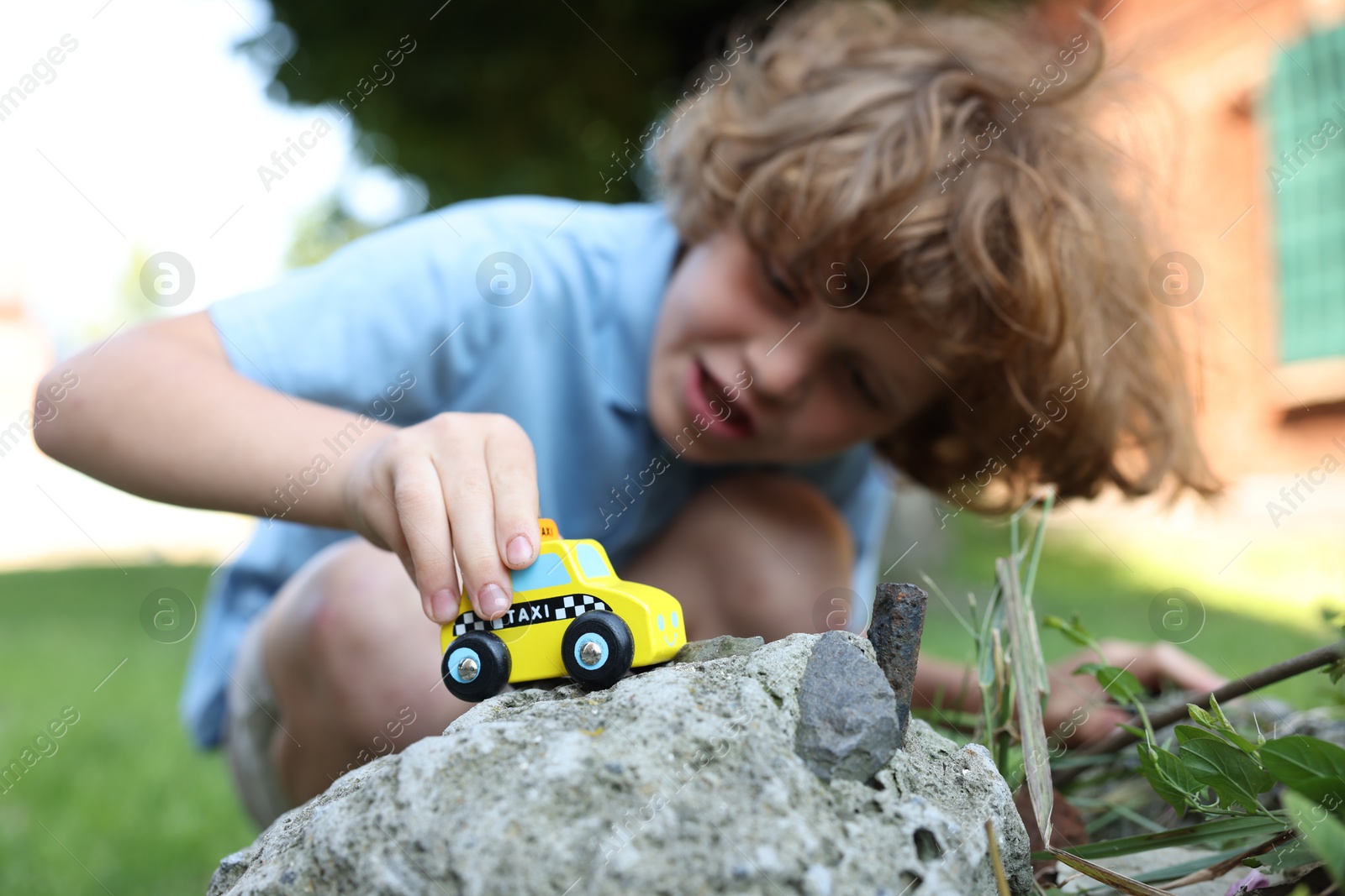 Little boy playing with toy car outdoors, selective focus Photo of Little boy playing with toy car outdoors, selective focus
