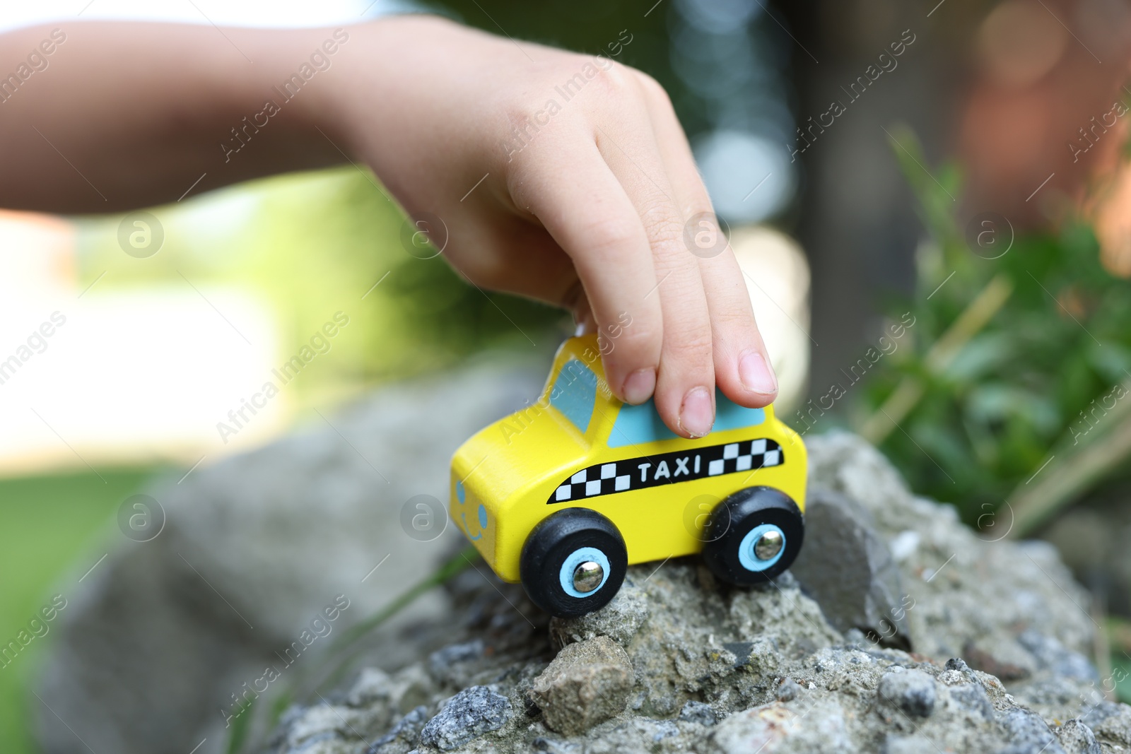 Photo of Little boy playing with toy car outdoors, closeup