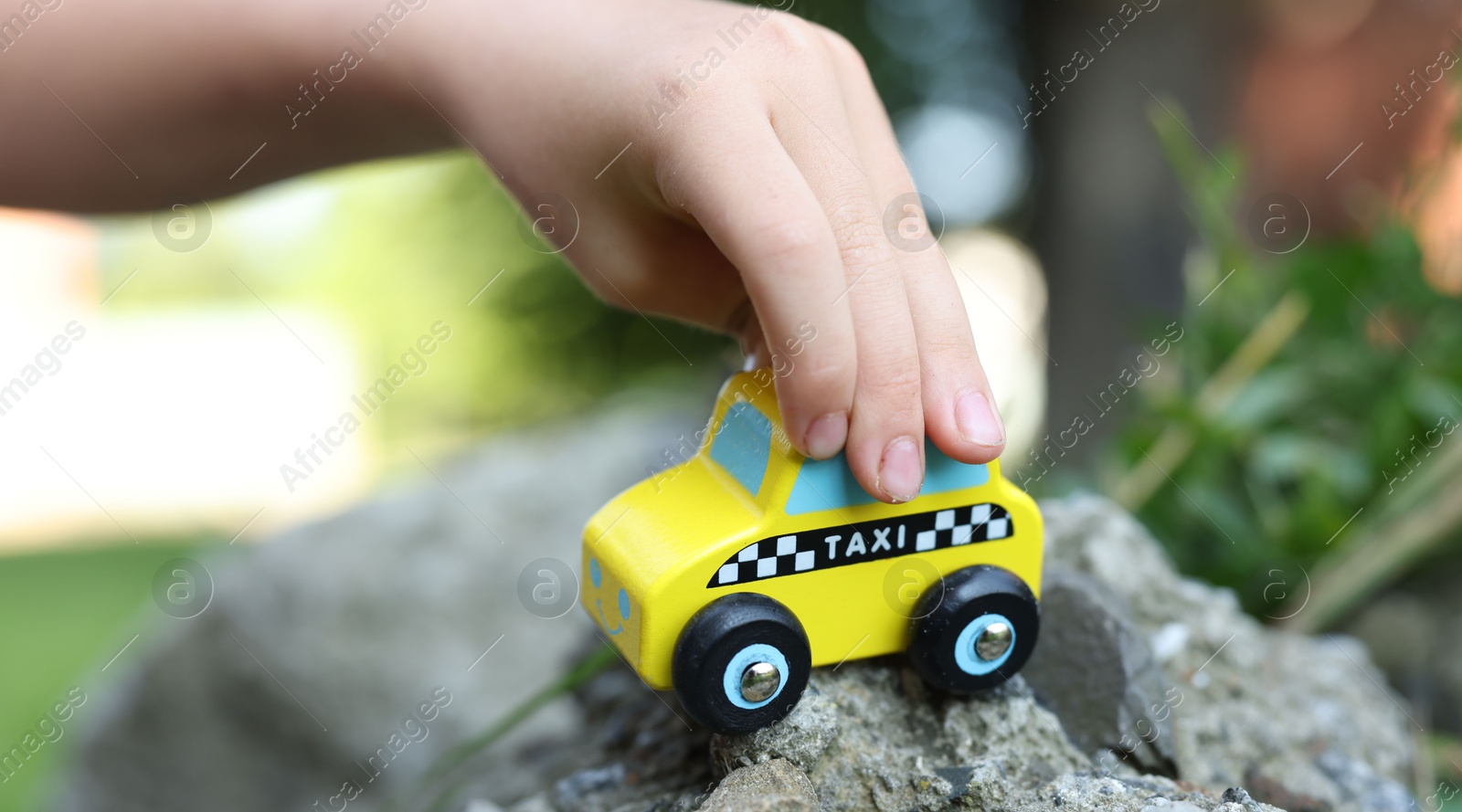 Little boy playing with toy car outdoors, closeup Photo of Little boy playing with toy car outdoors, closeup