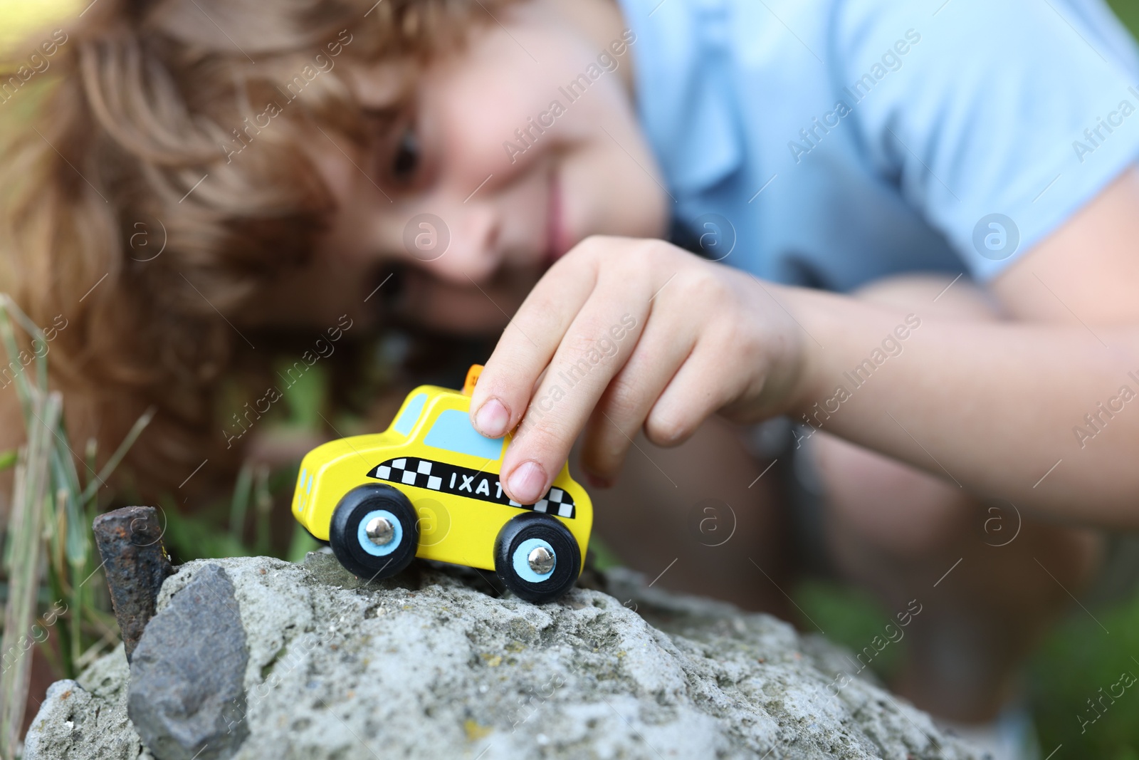 Little boy playing with toy car outdoors, selective focus Photo of Little boy playing with toy car outdoors, selective focus