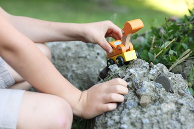 Photo of Little boy playing with toy car outdoors, closeup