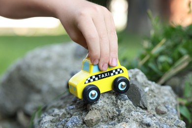 Photo of Little boy playing with toy car outdoors, closeup