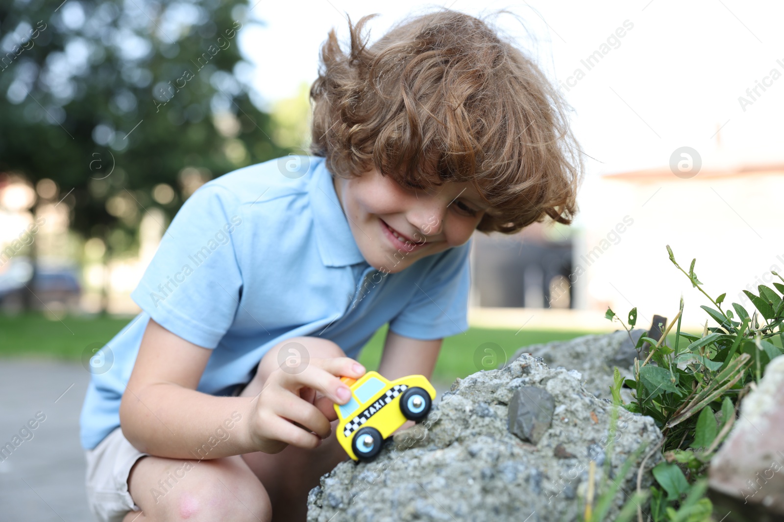 Little boy playing with toy car outdoors Photo of Little boy playing with toy car outdoors