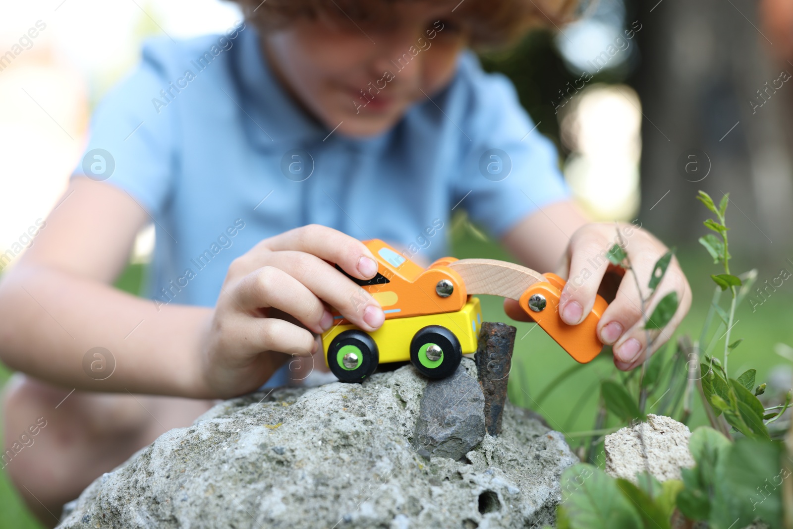 Little boy playing with toy car outdoors, selective focus Photo of Little boy playing with toy car outdoors, selective focus