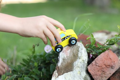 Photo of Little boy playing with toy car outdoors, closeup