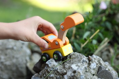 Photo of Little boy playing with toy car outdoors, closeup