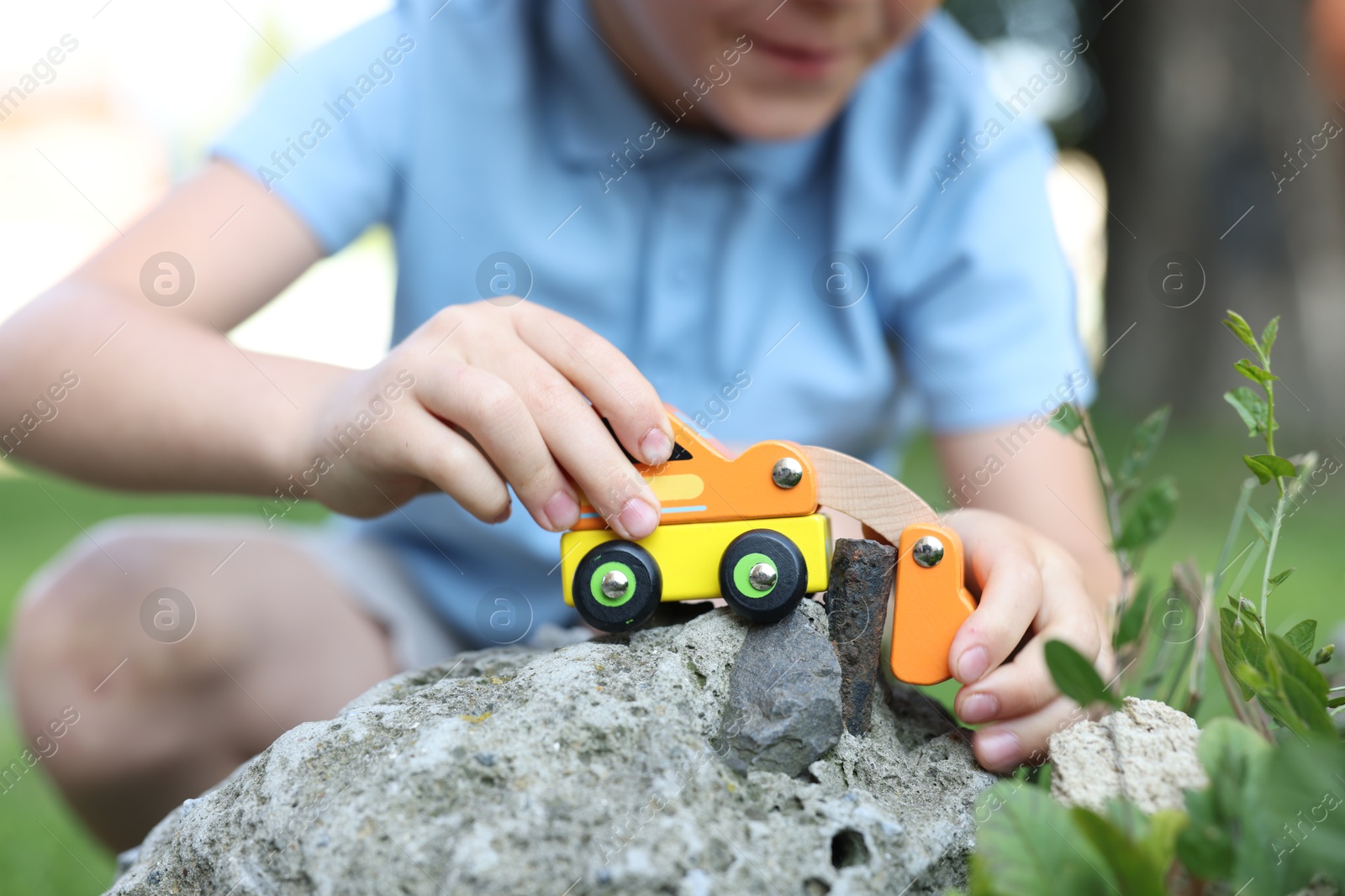 Little boy playing with toy car outdoors, closeup Photo of Little boy playing with toy car outdoors, closeup