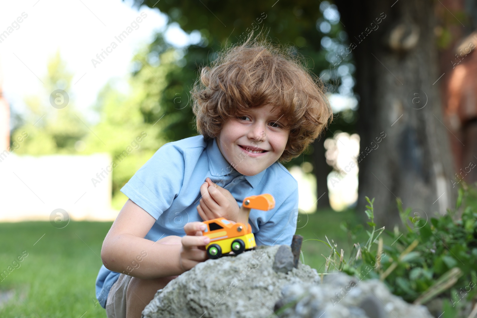 Little boy playing with toy car outdoors Photo of Little boy playing with toy car outdoors