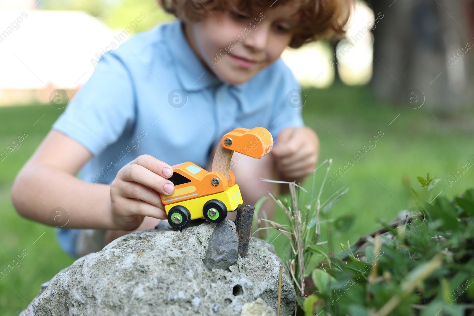 Little boy playing with toy car outdoors, selective focus Photo of Little boy playing with toy car outdoors, selective focus