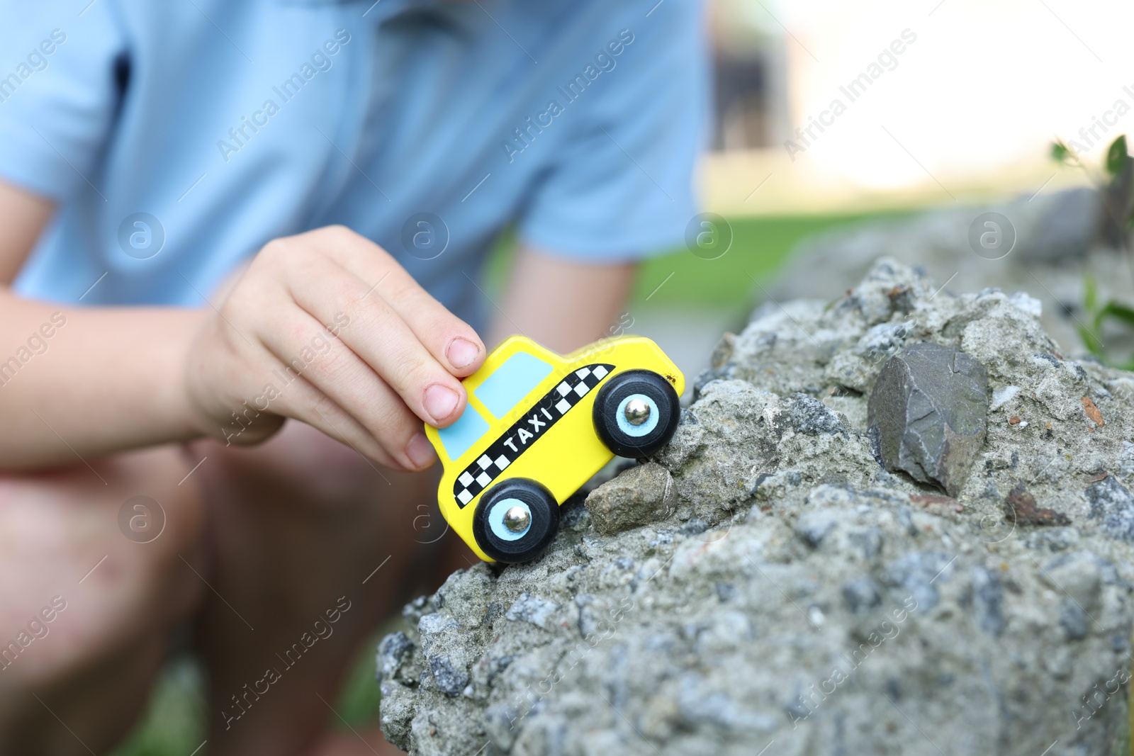Little boy playing with toy car outdoors, closeup Photo of Little boy playing with toy car outdoors, closeup